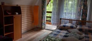 a bedroom with a bed and a large window at Domek na Mazurach. in Dłużek
