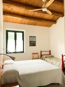 a bedroom with two beds and a ceiling fan at Casale Al Fiume in Grottazzolina