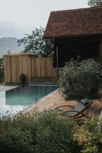 una piscina en un patio con una casa en FRANZL - privates Refugium AmWildbachberg, mit Infinitypool, Weinkeller und Privatsauna en Deutschlandsberg