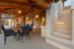 un patio con techo de madera, mesa y sillas en Villa in Kavran, en Kavran