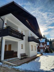 a white building with a bench in front of it at Falcade Dolomiti La Quiete piano terra in Fregona +20 photos