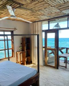 een slaapkamer met een bed en uitzicht op de oceaan bij Soul Rebel Lodge & Backpackers in Nkhata Bay