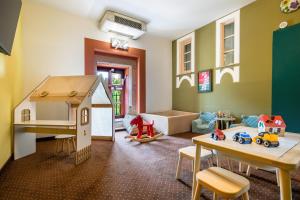 una sala de juegos para niños con una casa de muñecas y juguetes en Hotel Vécsecity Superior, en Hernádvécse