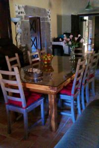 a dining room table with chairs and a vase of flowers at La Casona de Candamín in Candamin