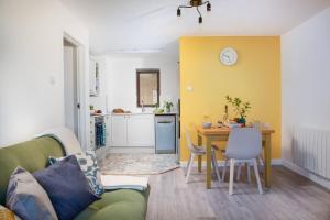 uma sala de estar com um sofá verde e uma mesa em Quiet family-friendly apartment 250 metres from beach and town em Newquay