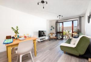 uma sala de estar com uma mesa e um sofá em Quiet family-friendly apartment 250 metres from beach and town em Newquay