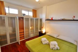1 dormitorio con 1 cama verde y 2 toallas en BiloBolo, en Bolonia