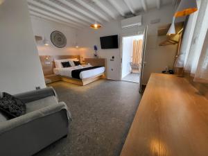 アノ・メラにあるMykonos Double Luxury Mini Suites - Adults onlyのベッドルーム(ベッド1台、ソファ、テレビ付)