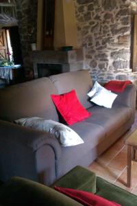a couch with pillows on it in a living room at La Casona de Candamín in Candamin