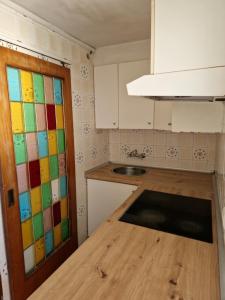 a kitchen with a colorful glass door and a sink at Apartamento cerca del centro in Vilanova i la Geltrú