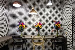 a table with four chairs and vases of flowers at Hotel Roma Vaticano in Rome