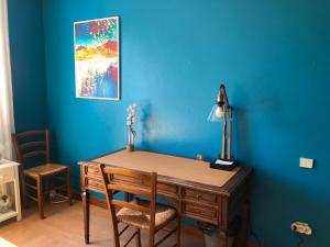 a desk in a room with a blue wall at Chambres avec piscine in Toulouse