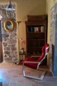 una silla roja en una habitación con estantería en La Casona de Candamín, en Candamin