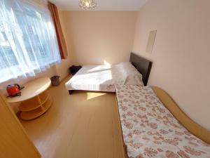 a room with two beds and a table and a window at Neringos 8 in Palanga