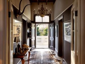 a hallway with a chandelier and a hallway with a door at Mukti in Nieu-Bethesda