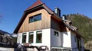 a house with a wooden roof on a mountain at Ferienwohnung Eisenerz 80m² in Eisenerz