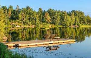 una mesa de picnic sentada en un muelle en un lago en Gorgeous Home In Herrng With Kitchen en Herräng