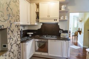 a kitchen with white cabinets and a stove top oven at Domus Fontis Pescaia in Spoleto