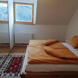 a large bed in a bedroom with a window at Ferienwohnung Eisenerz 80m² in Eisenerz