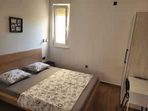 una piccola camera da letto con un letto e una finestra di MareAmor Studio Rab a Rab