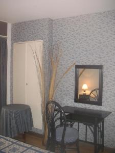 キャヴァレール・シュル・メールにあるLa ptit'Duchの鏡、テーブル、椅子が備わる客室です。