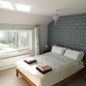 a bedroom with a bed with two towels on it at Hide on the Hill Cottage in Wells