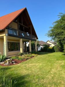 a house with a balcony and a grass yard at Landhaus mit Pool in Burgthann