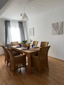 a dining room with a wooden table and chairs at Landhaus mit Pool in Burgthann