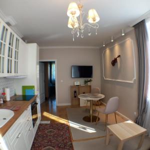 uma cozinha e sala de estar com uma mesa e uma televisão em Apartament Prowansalski em Gdansk