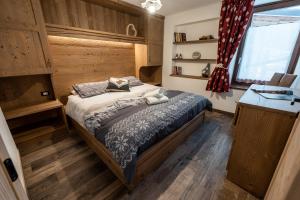 a bedroom with a bed in a room with wooden floors at Casa Marzari Lavarone - Appartamento Ginepro in Chiesa