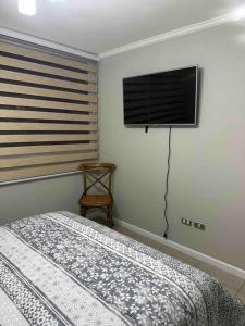 a bedroom with a bed and a flat screen tv at Descanso y Relajo Deluxe en La Serena in La Serena