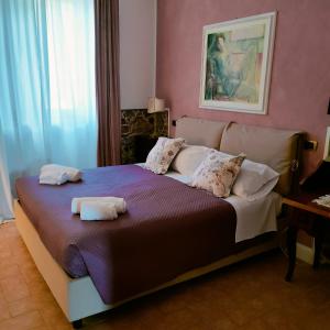 1 dormitorio con 1 cama con 2 toallas en Suite Eleven, en Castiglioncello