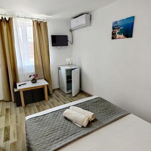 a bedroom with a bed and a television in it at Casa Georgeta 2 Mai-Punct Gastronomic Local-AROME DOBROGENE in 2 Mai