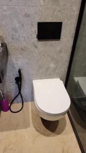 a white toilet in a bathroom with a hose at Bright Casablanca Apt in Casablanca