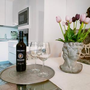 una botella de vino y dos copas de vino en una mesa en Suite Eleven, en Castiglioncello