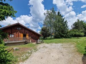 a log cabin with a porch and a bench at Chalet chaleureux au cœur du massif du haut Jura in Mignovillard