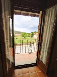 a door to a balcony with a view of a yard at Apartamento Puerta del Sol de 1 habitación in Candelario