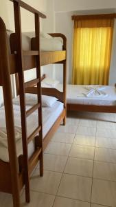 a room with three bunk beds and a window at Vila 3 in Himare