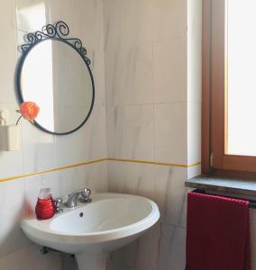ein Badezimmer mit einem weißen Waschbecken und einem Spiegel in der Unterkunft Villaggio Residence Chalet degli Ulivi in Marina di Camerota
