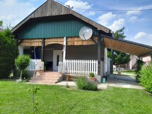 una casa con techo verde y valla blanca en Kuća za odmor 204 jezero Šoderica en Legrad