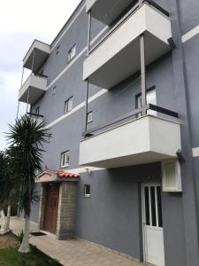 a blue building with a staircase and a palm tree at Vila 3 in Himare +3 photos