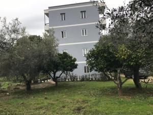 a white building with trees in front of it at Vila 3 in Himare