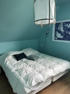 a bed in a room with a blue wall at Grande maison Quiberonnaise capacité jusqu'à 8 personnes in Quiberon