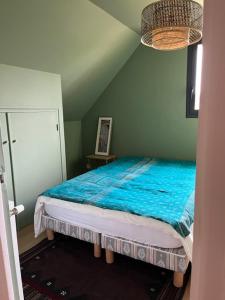 a bedroom with a bed with a blue comforter at Grande maison Quiberonnaise capacité jusqu'à 8 personnes in Quiberon