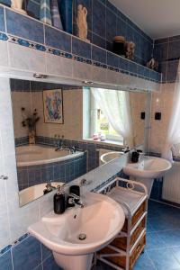 baño de azulejos azules con 2 lavabos y bañera en Vila Marcelka, en Broumov