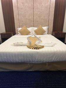 um quarto com uma cama com lençóis brancos em Kada Suites em Riyadh