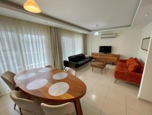 uma sala de estar com uma mesa e um sofá em SA Apartments! Crystal Family Suites em Alanya