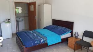 een slaapkamer met een bed met blauwe lakens en een badkamer bij POMERANIA Pokoje U Oliwii in Rewal