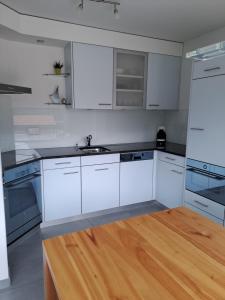 cocina con armarios blancos y suelo de madera en Chasa Azura, en Scuol 13 fotos más