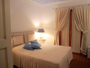 Un dormitorio con una cama con almohadas azules. en Villa Carola at Punta Ala (Sea & Golf Club View), en Punta Ala